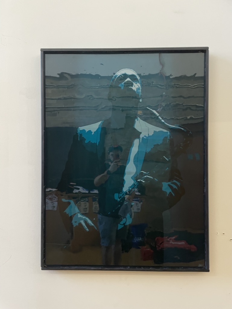 A printed and framed poster of an colorful illustrated poster of jazz saxophonist John Coltrane