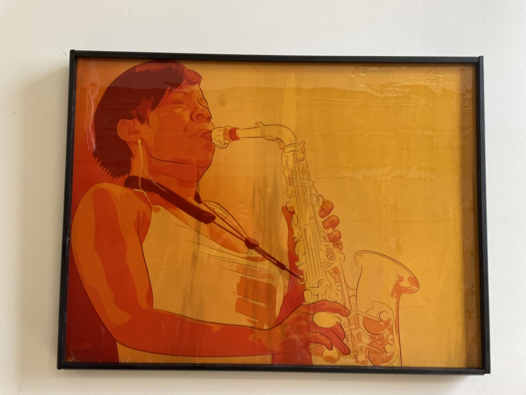 A printed and framed poster of an colorful illustrated poster of jazz saxophonist Tia Fuller