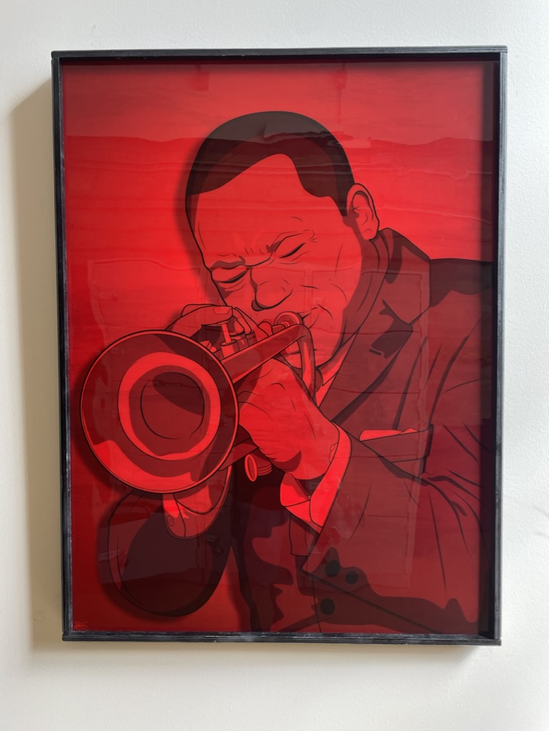 A printed and framed poster of an colorful illustrated poster of jazz trumpeter Clifford Brown.